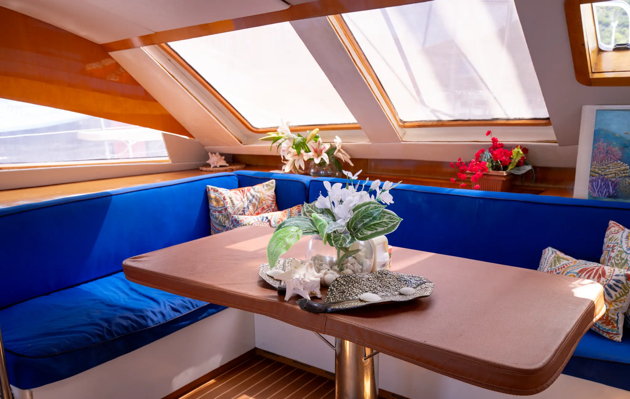 The Phoenix catamaran interior salon with blue velvet seating and skylight windows