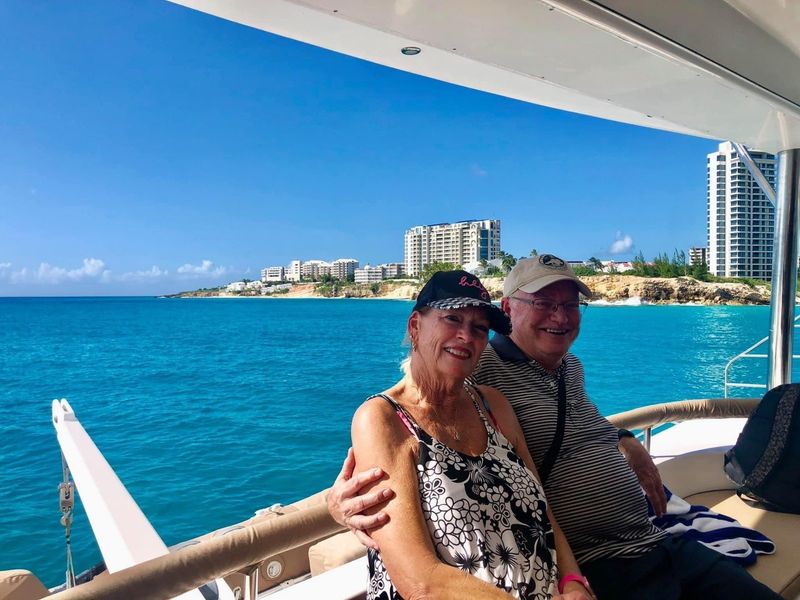 Couple reclining on sun deck cushions of Sail The Phoenix at Mullet Bay