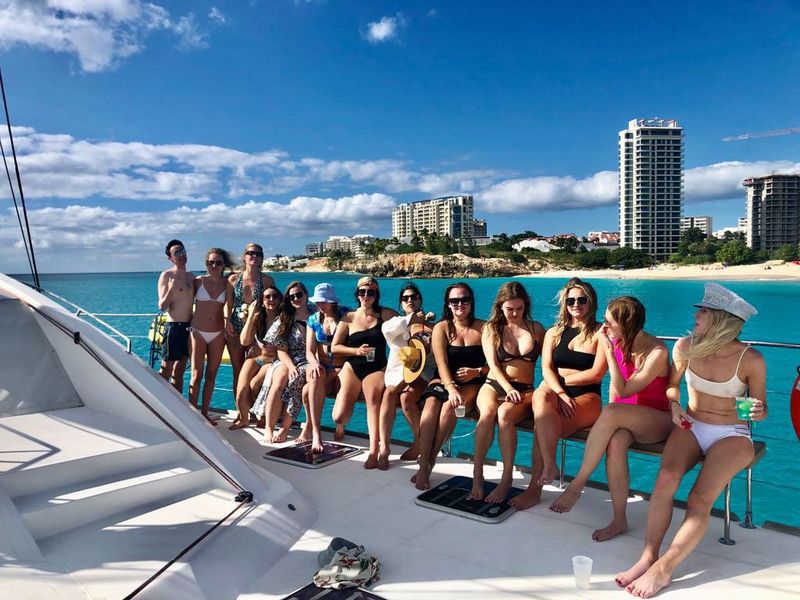 Bachelorette party sitting along the bow railing of Sail The Phoenix