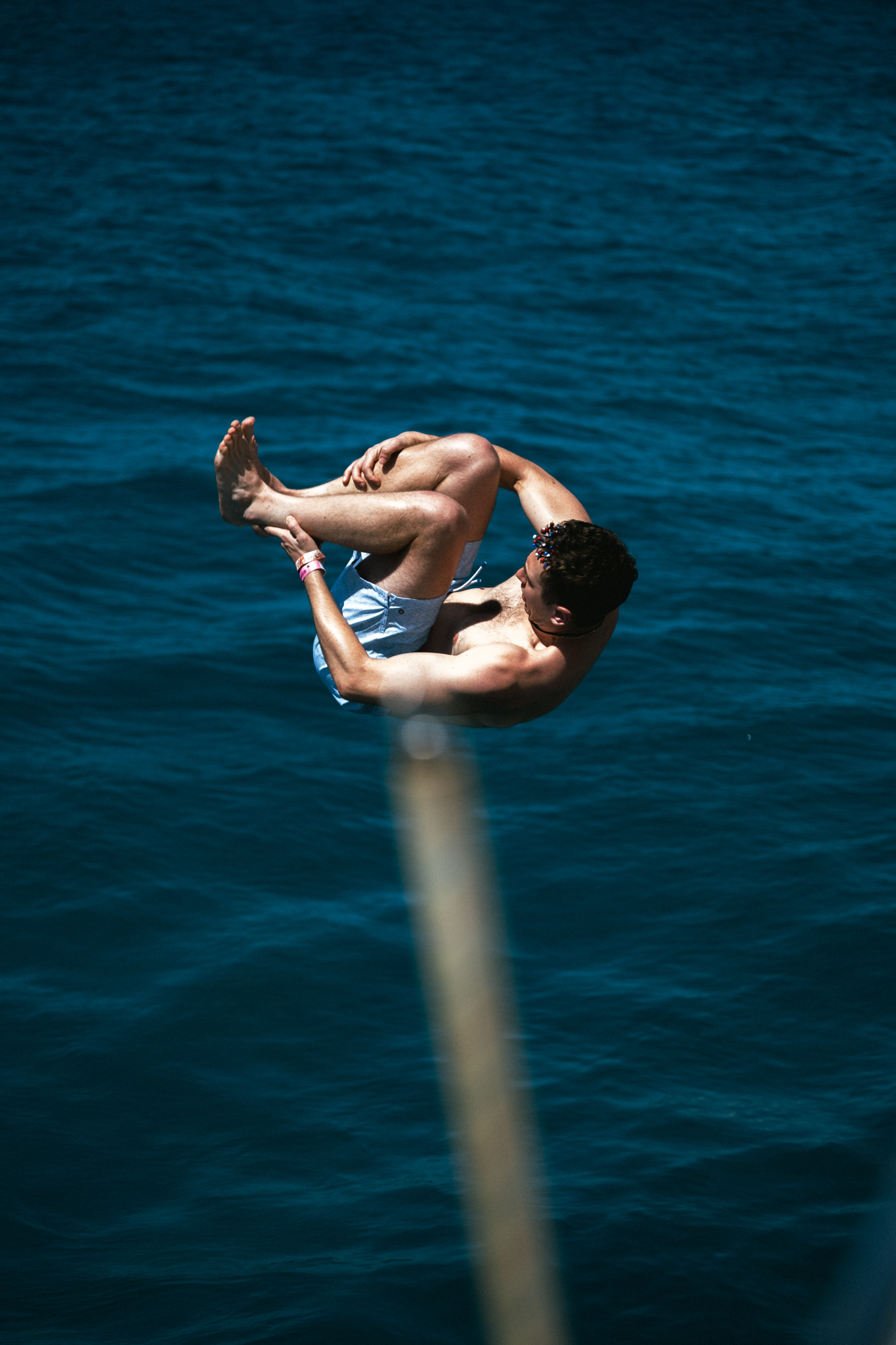 Guest doing a backflip off The Phoenix catamaran into the Caribbean Sea
